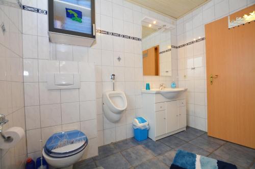 a bathroom with a toilet and a sink and a urinal at Haus Sonja in Büsum