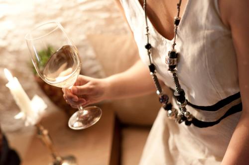 a woman is holding a glass of wine at Hotel Christof in Appiano sulla Strada del Vino