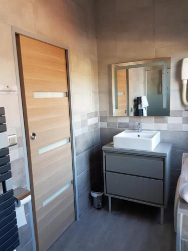 a bathroom with a sink and a mirror at LOGIS - Château de la Motte - Hôtel & Restaurant in Liessies