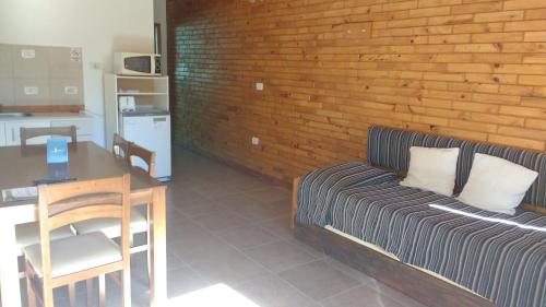 a room with a bed and a table and a table and chairs at Apart Dry Fly in Junín de los Andes