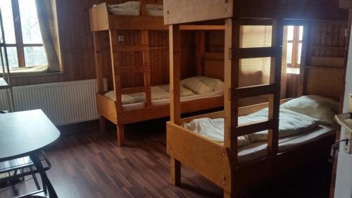 a room with three bunk beds and a table at Báró Eötvös Loránd Menedékház in Pilisszentkereszt