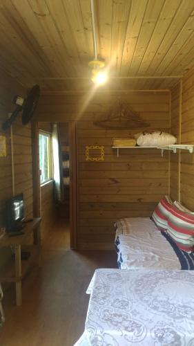 a bedroom with a bed in a wooden cabin at Ekontainer Hospedaria Praia Do Rosa in Praia do Rosa