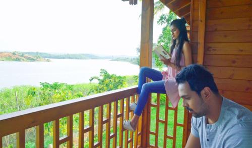 a man and a woman sitting on a porch at LakeRose Wayanad Resort in Ambalavayal