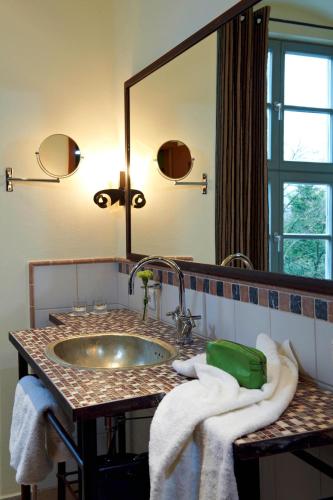 a bathroom with a sink and a mirror and towels at Kloster Hornbach in Hornbach