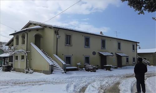 a man standing in the snow in front of a building at Biobagnolese Agriturismo in Orte