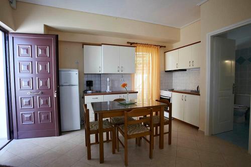 a kitchen with a table and chairs and a refrigerator at Sunday Apartments in Nafplio