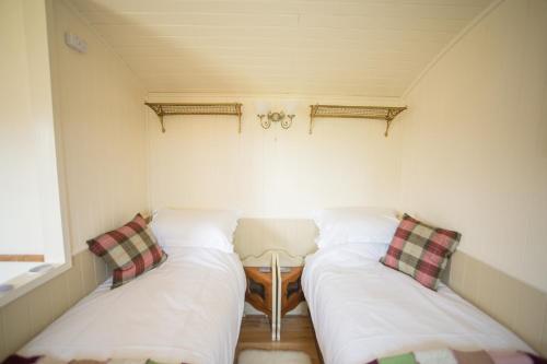 a small room with two beds and a table at The Hideaway Huts in Bardon Mill