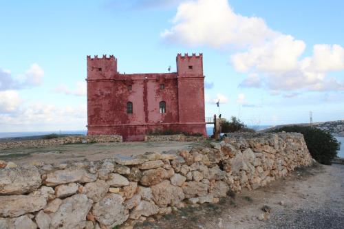 an old castle on top of a stone wall at Francis Flats Modern Penthouse in Mellieħa