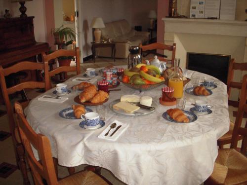 ein Tisch mit einer weißen Tischdecke und Essen darauf in der Unterkunft La Maison des Aurélines in Puisseguin