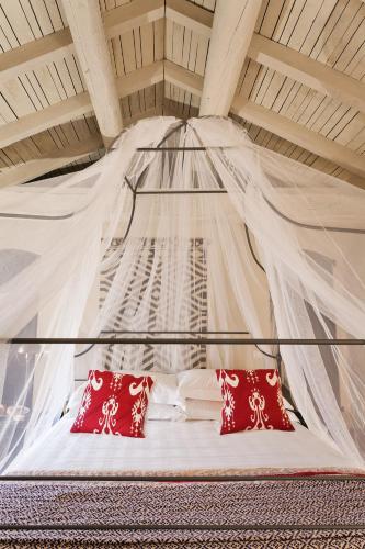 a bed with two red pillows in a room at Castello di Gabiano in Gabiano