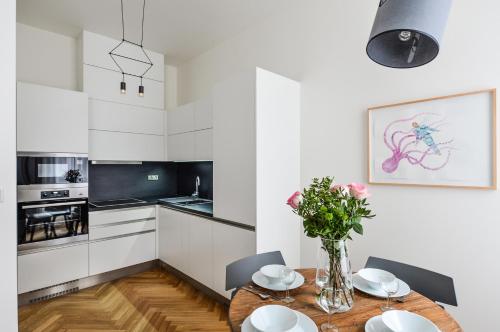 a kitchen with a wooden table with chairs and a vase of flowers at Masarykova N°30 in Brno
