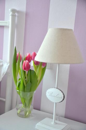 a lamp and a vase of flowers on a table at IL CILIEGIO Affittacamere in Stresa