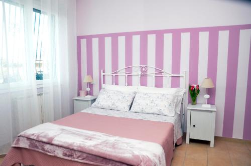 a bedroom with a pink and white striped wall at IL CILIEGIO Affittacamere in Stresa