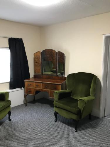 a room with a desk and two chairs and a mirror at The Black Swan Inn in Leominster