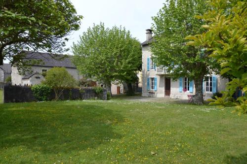 ein weißes Haus mit einem Hof mit Bäumen und Gras in der Unterkunft L'Estancat in Pardies-Piétat