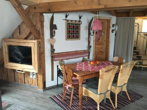 ヴィリンゲンにあるFerienwohnung im kleinen Landhausのダイニングルーム(木製テーブル、椅子付)