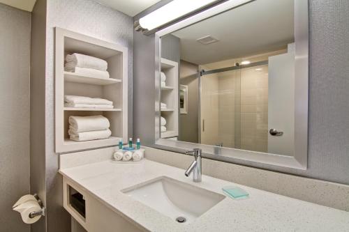a bathroom with a sink and a mirror at Holiday Inn Express & Suites Oshawa Downtown - Toronto Area by IHG in Oshawa