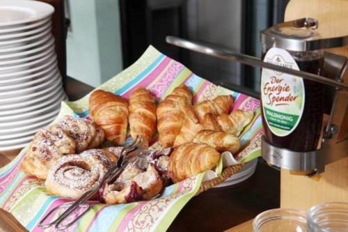 a basket of croissants and pastries on a table at AKZENT Hotel Altes Casino in Fulda