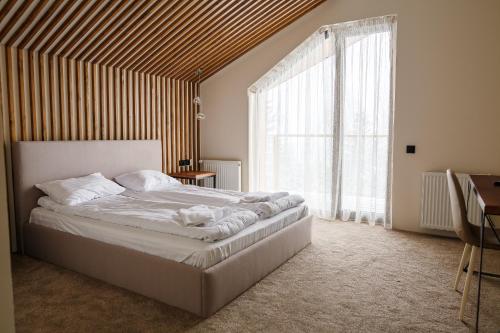 a bedroom with a bed and a large window at Gogodz Chalet Resort in Yablunytsya