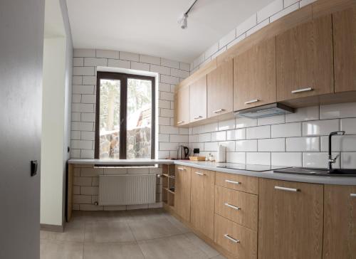 a kitchen with wooden cabinets and a window at Gogodz Chalet Resort in Yablunytsya