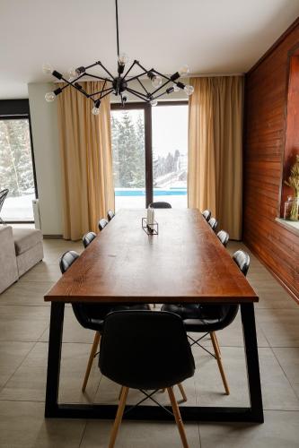 a dining room with a large wooden table and chairs at Gogodz Chalet Resort in Yablunytsya