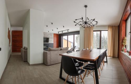a dining room and living room with a table and chairs at Gogodz Chalet Resort in Yablunytsya