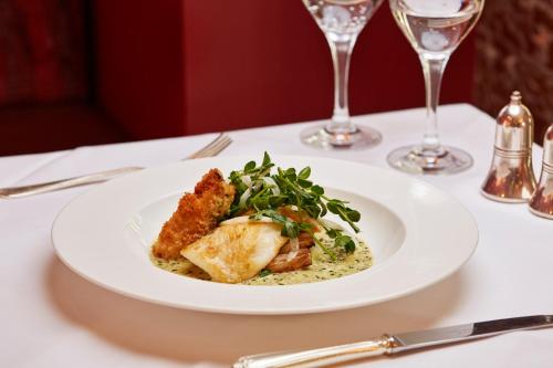a white plate of food on a table at Ockenden Manor Hotel & Spa in Cuckfield