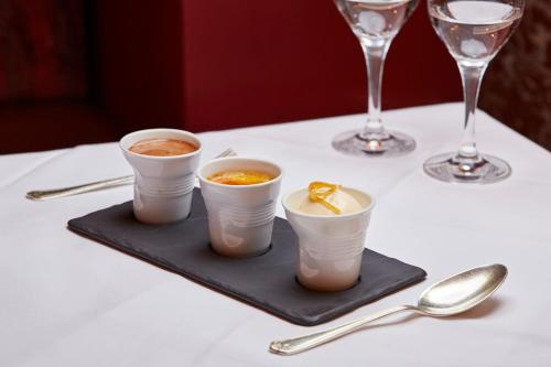 a table with three cups of coffee and wine glasses at Ockenden Manor Hotel & Spa in Cuckfield