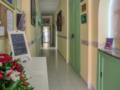 a hallway with green and yellow walls and a chalkboard at B&B La Pineta in Orbetello