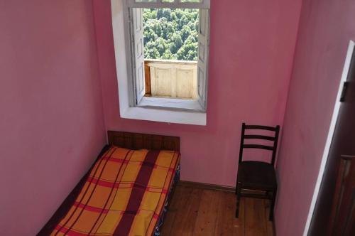 Cette petite chambre comprend un lit et une fenêtre. dans l'établissement Century House of Larisa, à Mestia