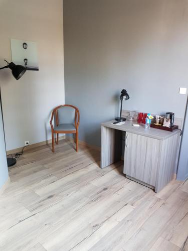 an empty room with a desk and a chair at LOGIS - Château de la Motte - Hôtel & Restaurant in Liessies