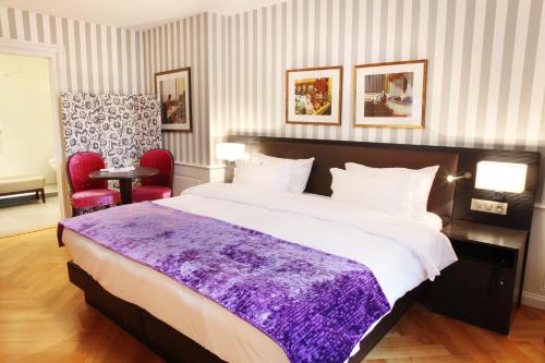 a bedroom with a large bed with a purple blanket at Logis Hôtel Ettenheim in Strasbourg