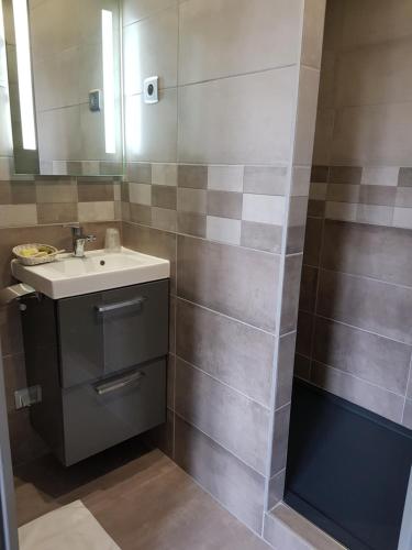 a bathroom with a sink and a mirror at LOGIS - Château de la Motte - Hôtel & Restaurant in Liessies