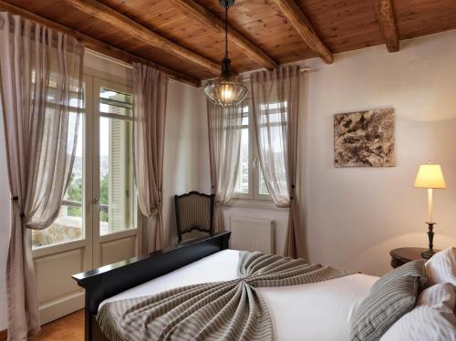 ein Schlafzimmer mit einem Bett und einem großen Fenster in der Unterkunft Plagia Villas in Finikas