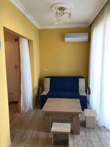 uma sala de estar com um sofá azul e uma mesa em Griboedovi N.6 em Batumi