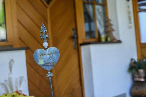 a wooden door with a heart shaped sign on it at Alpasella Ferienwohnungen in Sankt Gallenkirch