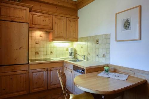 a kitchen with wooden cabinets and a wooden table at Alpasella Ferienwohnungen in Sankt Gallenkirch