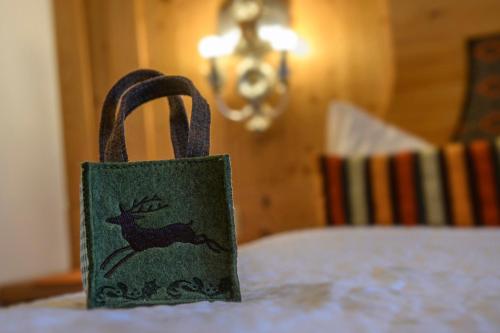 a green bag with a deer on it sitting on a table at Alpasella Ferienwohnungen in Sankt Gallenkirch