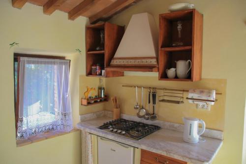 a small kitchen with a stove and a window at Podere Piandicava in Castelnuovo di Val di Cecina