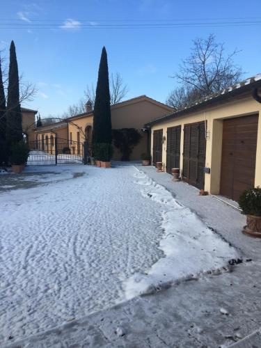a driveway covered in snow next to a house at La Renaia in Cortona