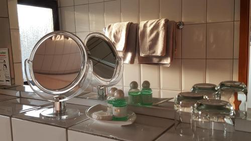 a bathroom counter with a mirror and a sink at Landhotel Linden am Venekotensee in Niederkrüchten