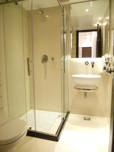 a shower with a sink and a toilet in a bathroom at Hotel Grand Godwin - Free Airport Pick-Up in New Delhi