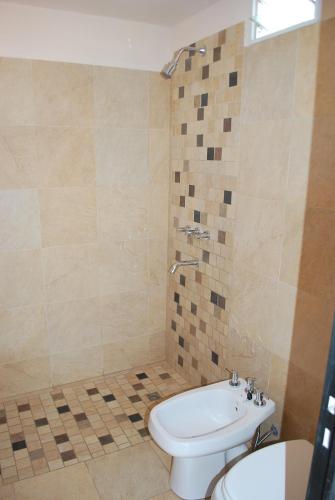 a bathroom with a toilet and a sink at Apart Hotel El Portico in Villa Carlos Paz