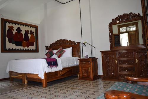 a bedroom with a bed and a dresser and a mirror at Casa Meba Hotel Boutique in Tampico