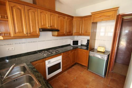 a kitchen with wooden cabinets and a stainless steel refrigerator at Villa rustical 14 in Montroig