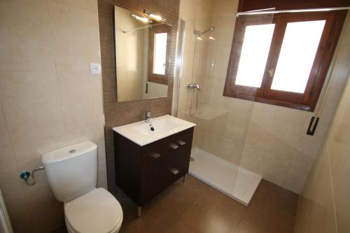 a bathroom with a toilet and a sink and a mirror at Villa rustical 14 in Montroig