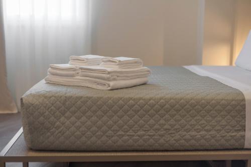 einen Stapel Handtücher auf dem Bett in der Unterkunft In Dies Affittacamere in Matera