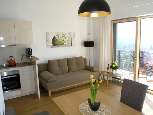 a living room with a couch and a table at Apartmenthaus STYRIA in Bad Gleichenberg