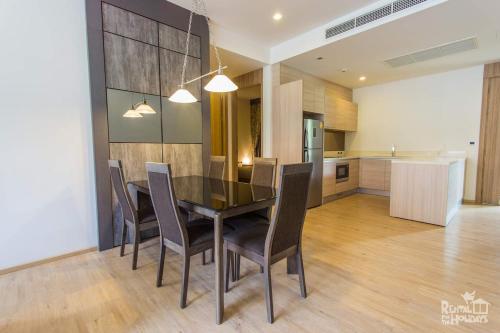 a dining room with a table and chairs and a kitchen at Baan Mai Khao Condominium in Mai Khao Beach