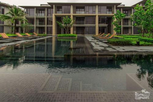 a swimming pool in front of a building at Baan Mai Khao Condominium in Mai Khao Beach